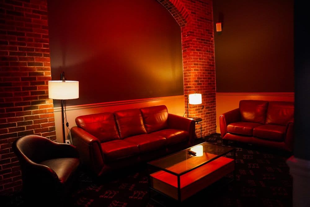 A VIP lounge with leather couches and warm lamp light
